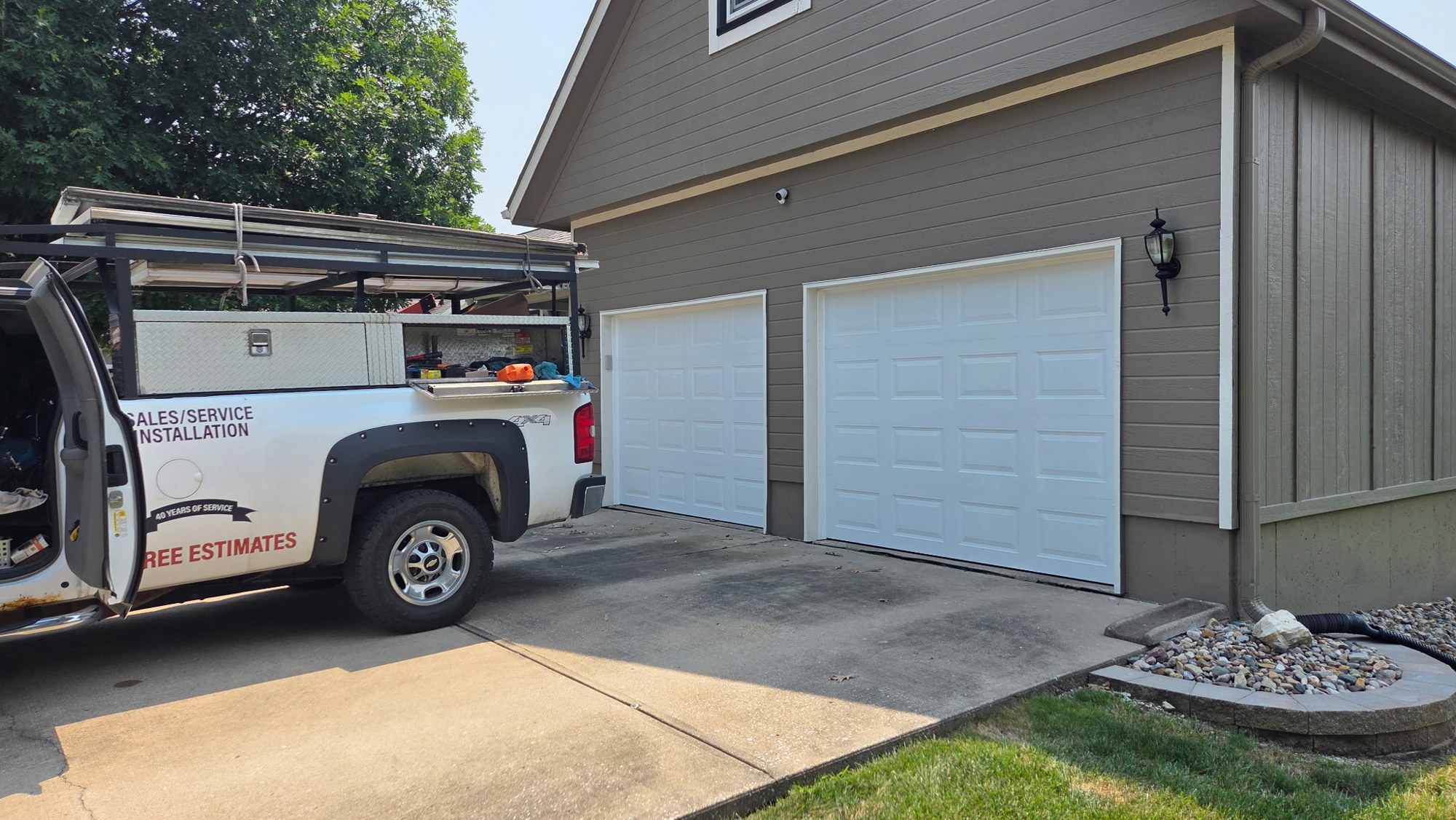 Arrowhead Door Co truck in front of new white garage doors