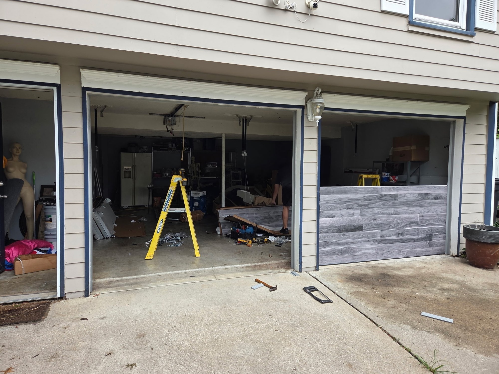 Gray woodgrain garage door installation in progress